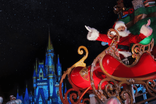 Santa in his sleigh silhouetted against Cinderella Castle at Walt Disney World during Christmas, one of the busiest times of the year to visit Disney World.