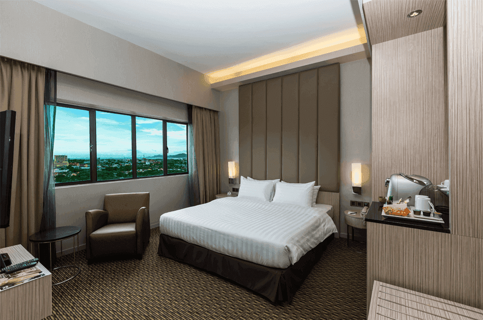 King-size bed with a single sofa in Suite at Sunway Hotel Seberang Jaya