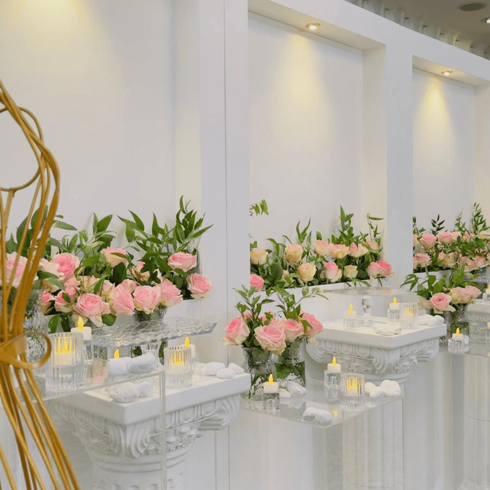 طاولة مزينة بالورود والشموع في قاعة كورال في فندق ورويك الدوحة.