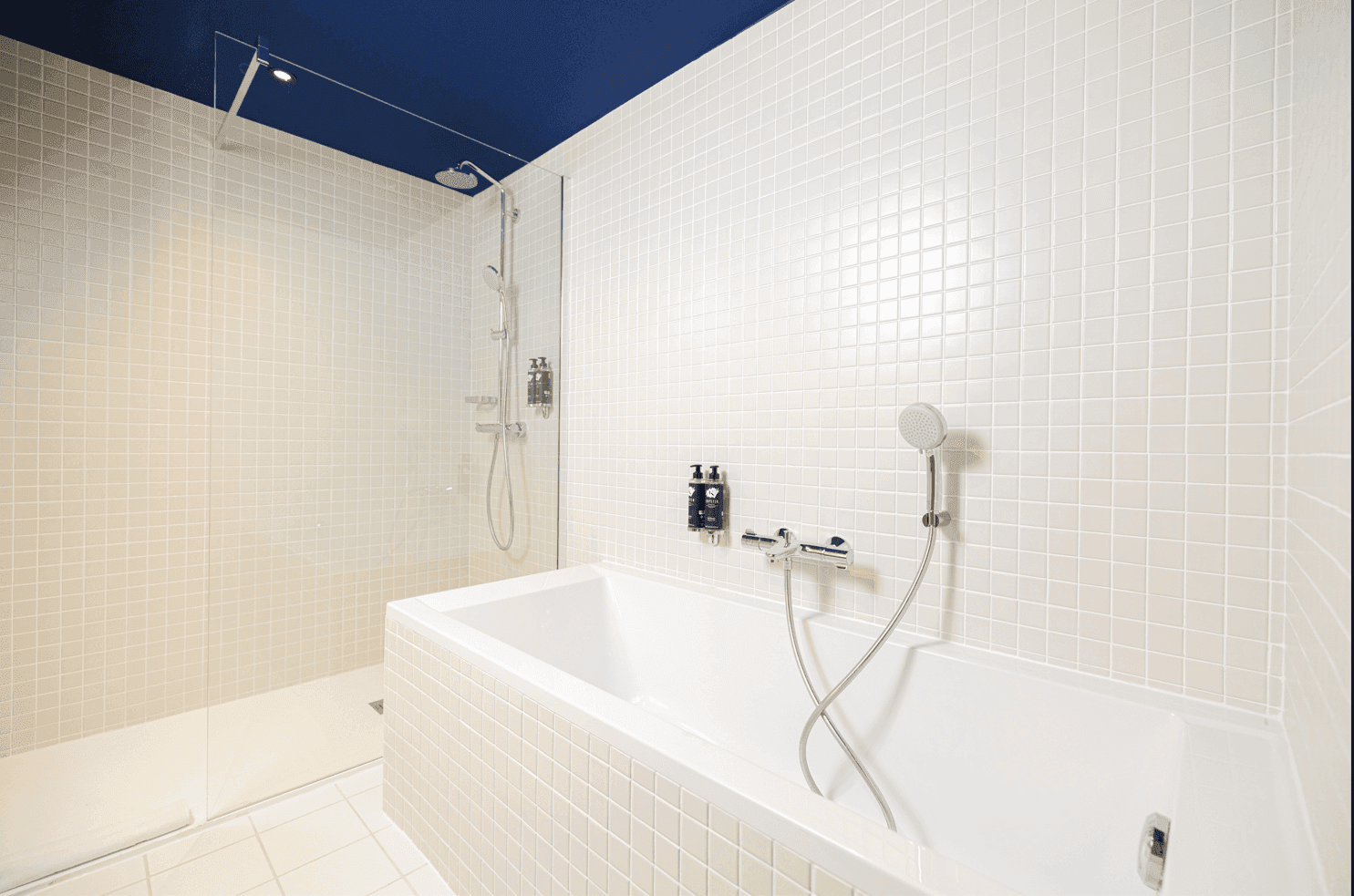 Bathroom shower & bathtub in a Suite at Kopster Hotel Paris Ouest Colombes