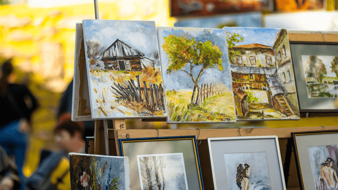 Watercolor paintings and framed artwork displayed on outdoor market stall at Margaret River Town Square Markets