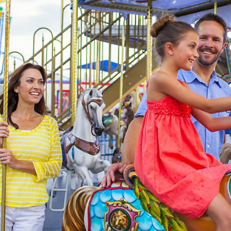 A family in a carousel at a park near Mystic Dunes Resort