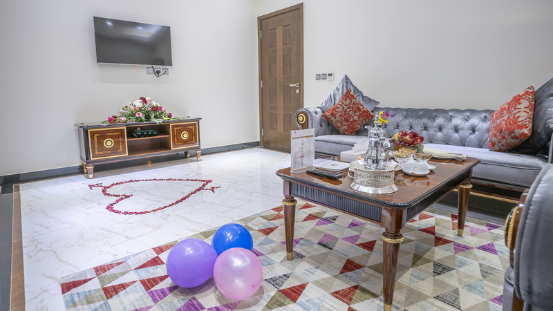 Cozy living room with a couch, table, and Honeymoon Welcome Amenities at Makeen Homes by Warwick - Riyadh