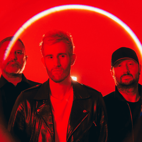 Group of men in black clothing with red neon circle in the middle of image.