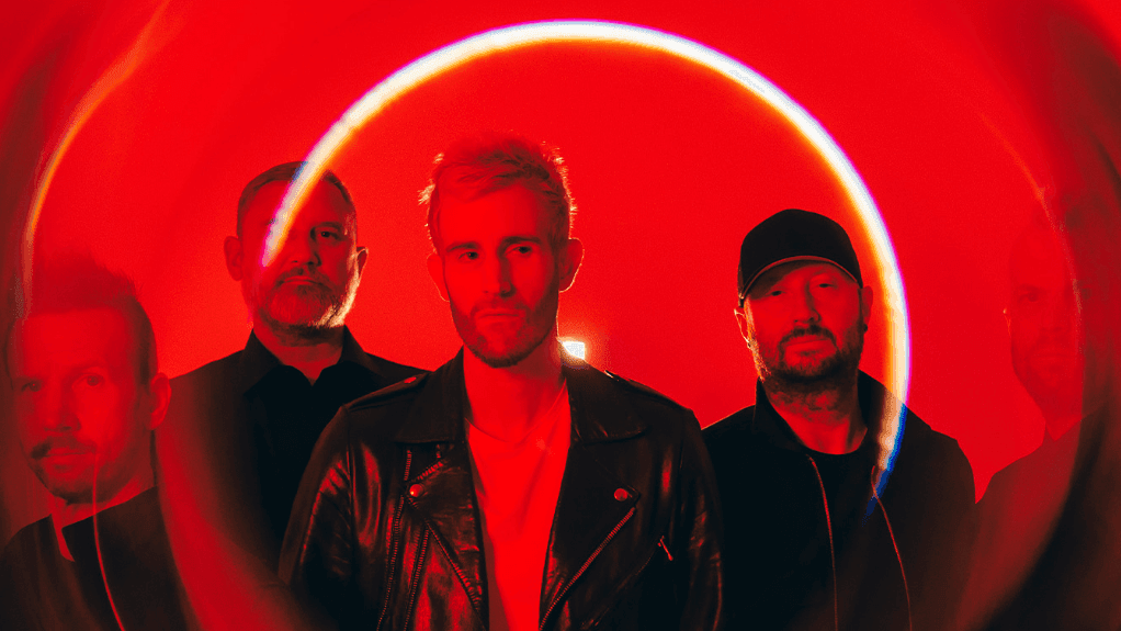 Group of men in black clothing with red neon circle in the middle of image.