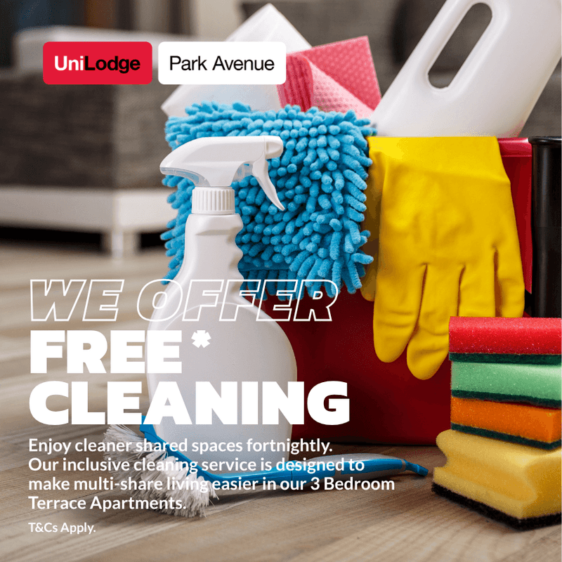 Cleaning supplies including spray bottle, sponges, gloves, and microfiber cloth arranged in a red bucket at UniLodge Park Avenue.