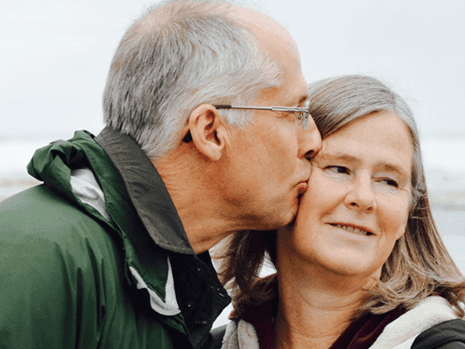 Close-up of an elderly couple sharing a romantic kiss near Harrison Lake Hotel