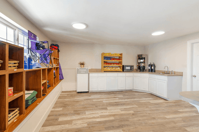 Spacious room at Ogunquit Hotel and Suites with shelves of snacks, a kitchenette, a microwave, and a coffee station