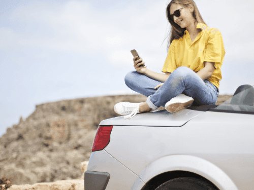 A lady sitting on a car near Hotel Halifax