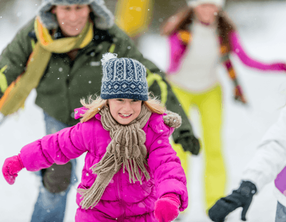 A young girl and her family enjoy ice skating at our Avalon hotel