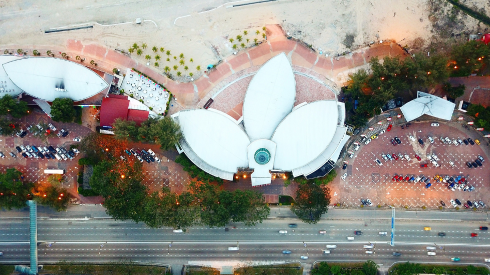 Aerial view of a lotus-shaped building next to a road at twilight near Sunway Hotel Big Box
