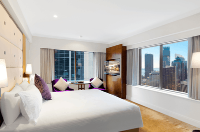 Large Bed, lounge chairs, TV & city view Bedroom at Amora Hotel