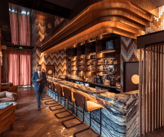Modern interior of Brooksy Bar with a marble countertop, illuminated drink shelves, and warm decor at Amora Hotel Sydney