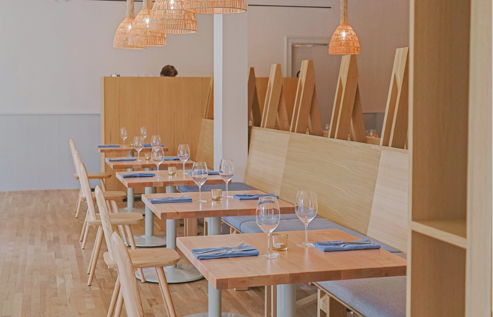 An assorment of dishes showing the diffrenet plates offered at the resturaunt. With coconut yougurt, bacon, fried eggs, roasted chicken breast, in house made salad, and a panini sandwich