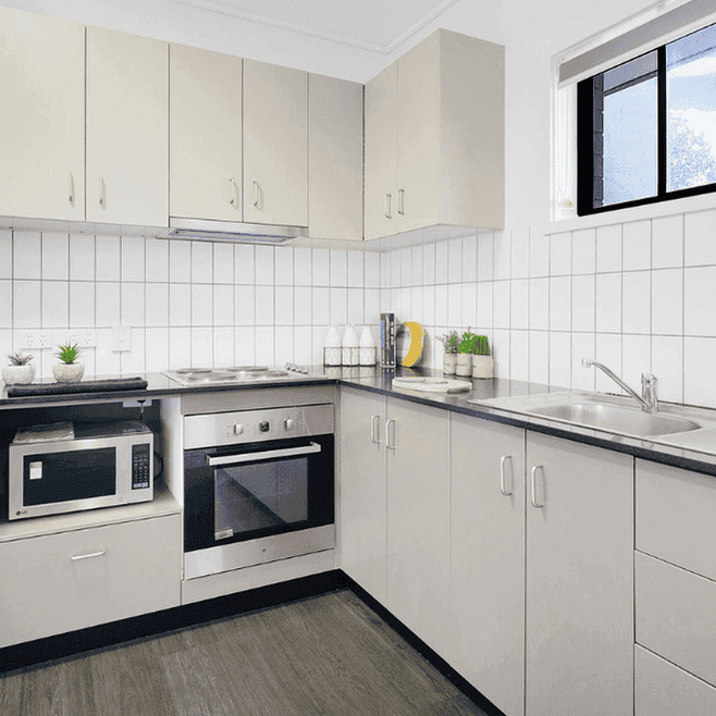 Modern kitchen with white cabinetry, stainless steel appliances, and white tile backsplash at Springfield Central
