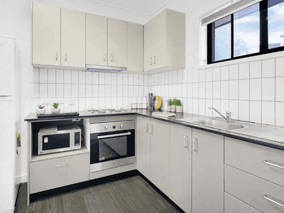 Modern kitchen with white cabinetry, stainless steel appliances, and white tile backsplash at Springfield Central