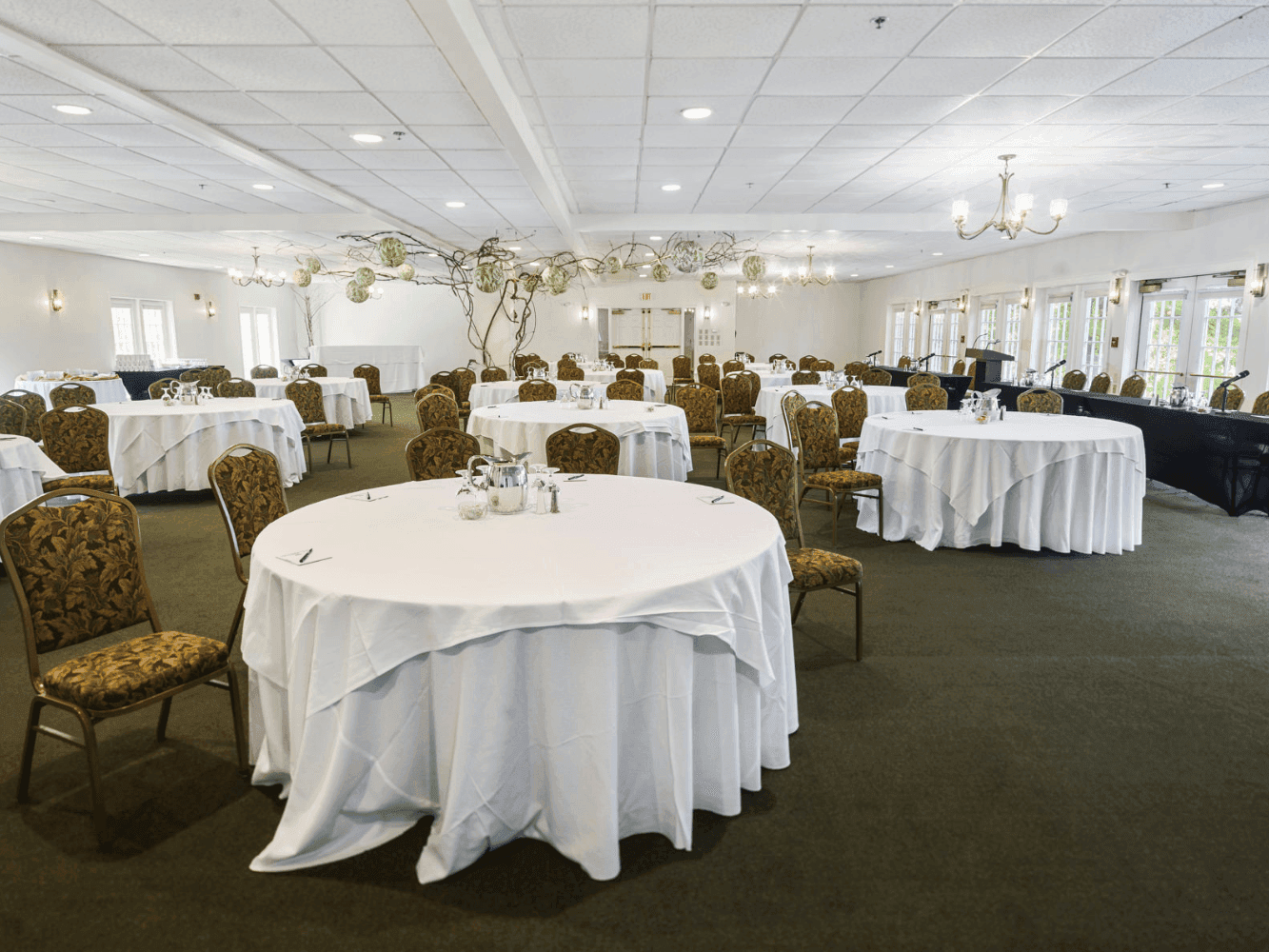 Banquet tables arranged in Casco Bay Room with carpeted floors at Harraseeket Inn
