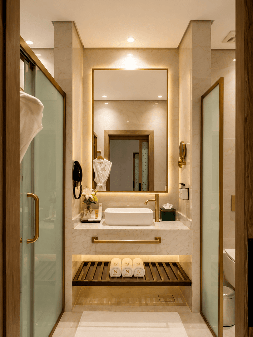 Vanity under mirror between glass doors in Deluxe Room at Naviti by Warwick Jeddah, featuring a peaceful boutique stay