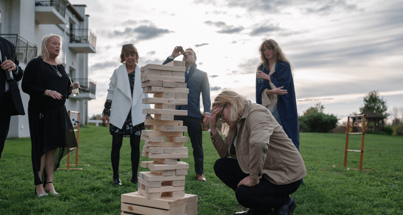 Guests playing a giant wooden block stacking game on the lawn beside the building at La Tourelle Inn and Spa