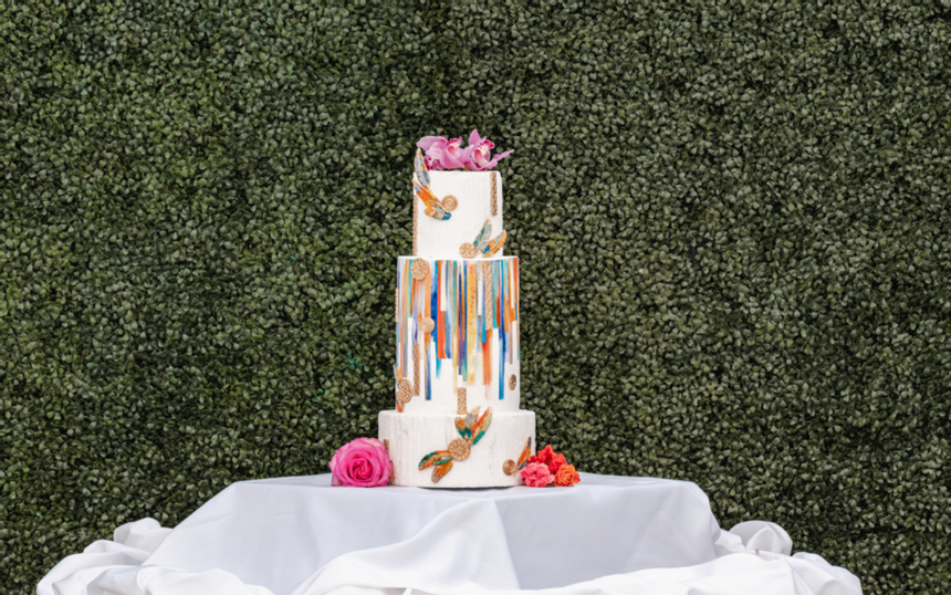 Wedding cake with color by a grass wall at our Avalon wedding venue