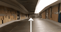 Modern indoor walkway with wood paneled walls and overhead linear light pointing forward at Hotel X Toronto's concourse