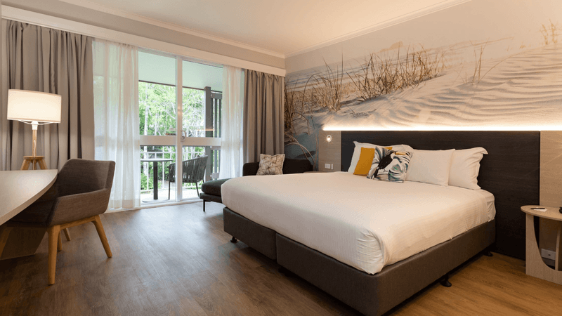 Work desk facing the bed by the windows with wooden floors in Executive Rooms at Novotel Sunshine Coast Resort