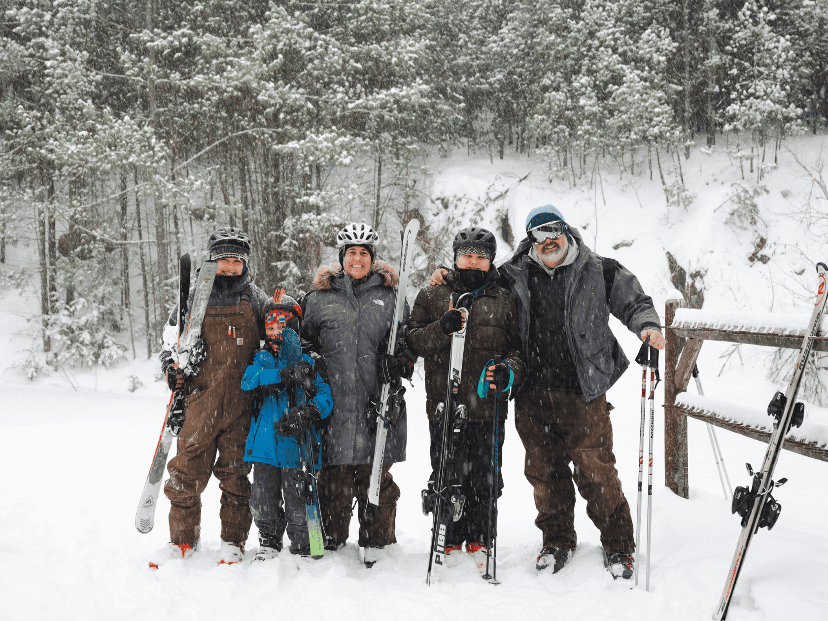 Winter adventure captured: a family of skiers posing atop a stunning snow-capped mountain