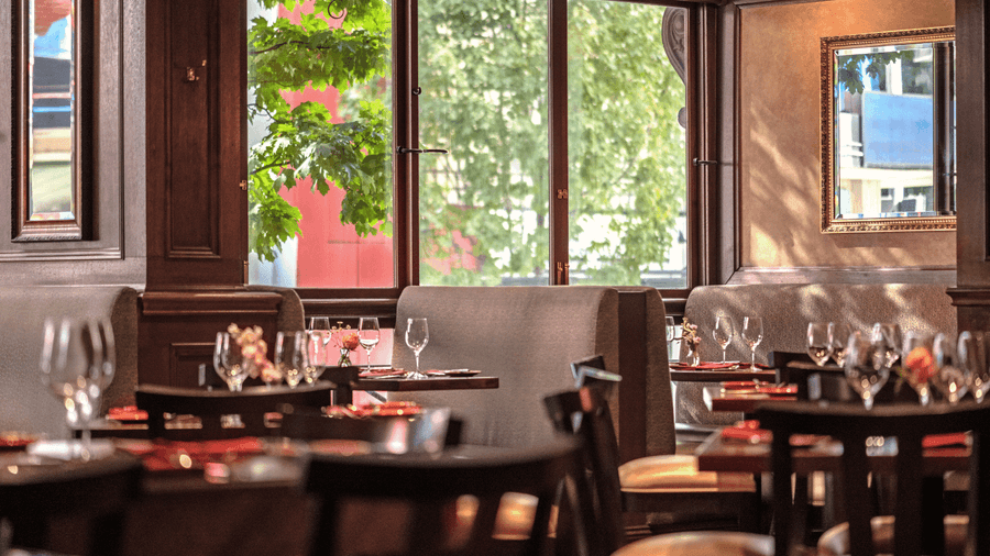 Elegant dining area with large windows and wooden furniture at Warwick Seattle سياتل