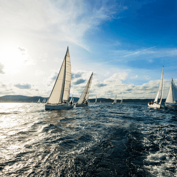 Sailboats sailing in the ocean with a clear blue sky near Golf Hotel Punta Ala