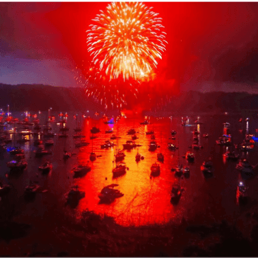 Boats illuminated with red and blue lights during Two Harbors Fireworks Motor Tour.