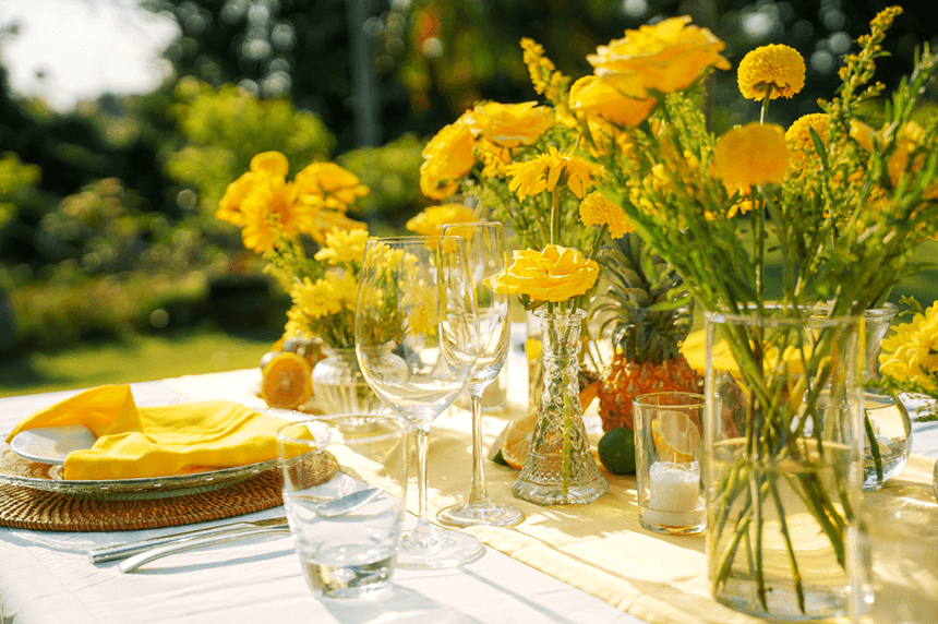 Meja makan ditata dengan anggun dengan bunga kuning dan piring di Peppers Seminyak