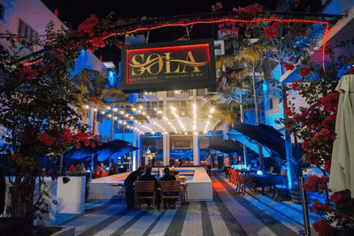 An outdoor dining area in Sola Restaurant of Fairwind Hotel Miami at night