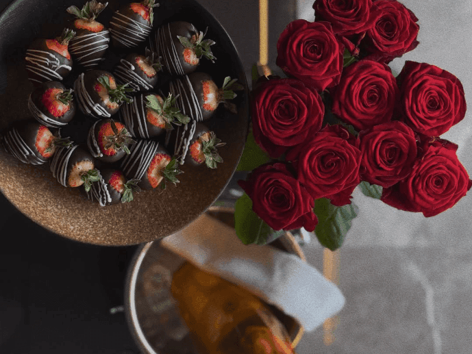 Chokoladeklædte jordbær, røde roser og champagne til Valentinsdag.