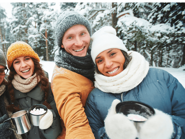 Friends drinking hot cocoa in the snow