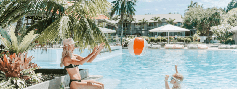 Mother & son playing with a beach ball in the pool on a sunny day at Novotel Sunshine Coast Resort
