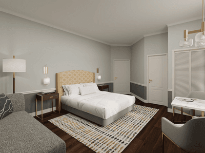 Bed between nightstands near a grey lounge sofa and a small dining table in a room at La Tourelle Hotel and Spa