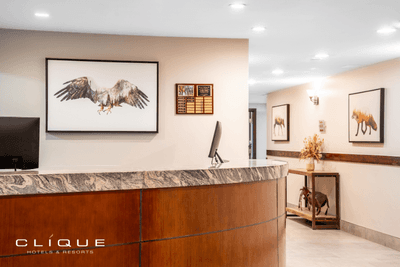 Reception desk at Falcon Crest Lodge features a granite countertop and wood paneling, with artworks