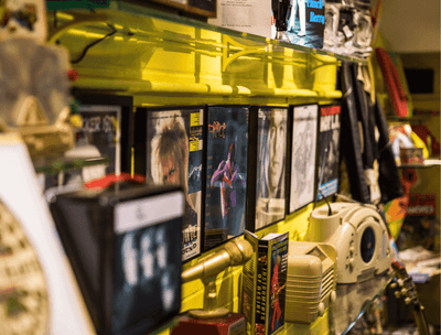 A yellow wall with magazines and music items at The Verb Hotel