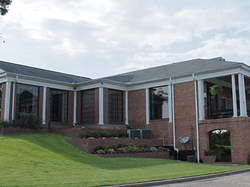 a large brick building with a grassy lawn