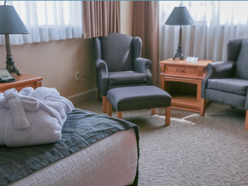 Lounge area with nightstands on side desks by sofas at The Glenmore Inn & Convention Centre