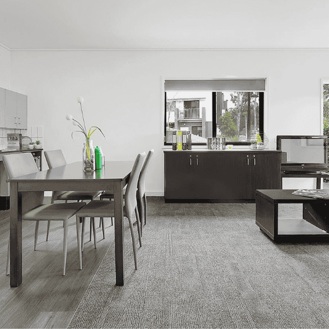 Modern open-plan living area with dining table, kitchen, and dark wood furniture at Springfield Central