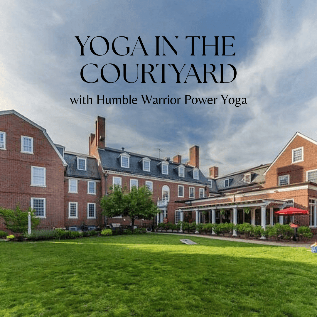 A courtyard with green grass and a large brick building with text