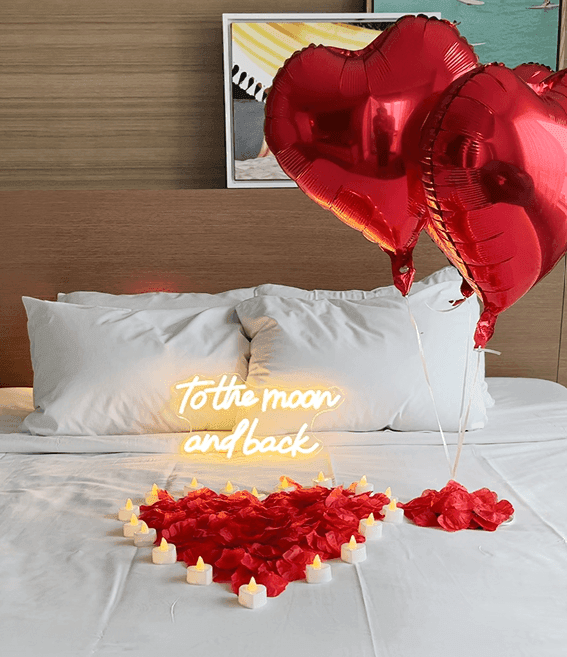 a bed set up with rose pedals and balloons for Valentine's Day at Diplomat Resort 