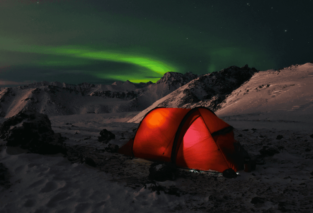 tent lit from within among the northern lights near anchorage, ak