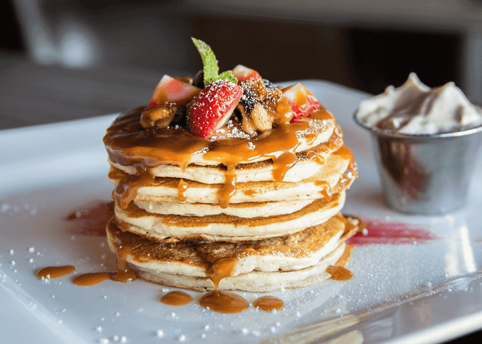 Close-up of pancakes and honey served at Anchorage by the Sea