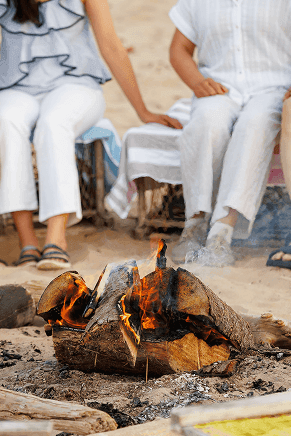 Guests sitting around a cozy beach campfire, showcasing the resort\'s PEI Canada charm at Rodd Crowbush Resort