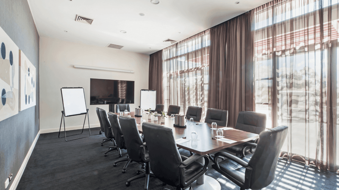 Boardroom One with a long table, black chairs, and abstract art on the wall at Mercure Kooindah Waters