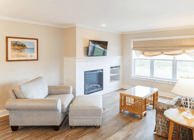 Cozy living room with wall-mounted TV and fireplace at Rodd Hotels & Resorts, ideal for Charlottetown accommodations