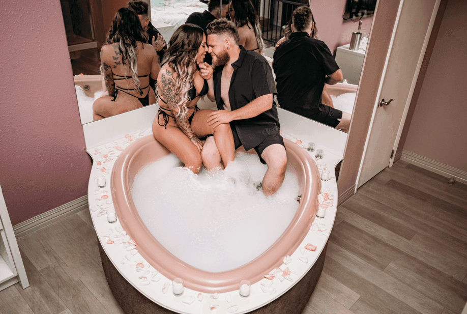 Couple enjoying a bubble bath in a tub, surrounded by mirrored walls at Cove Pocono Resorts
