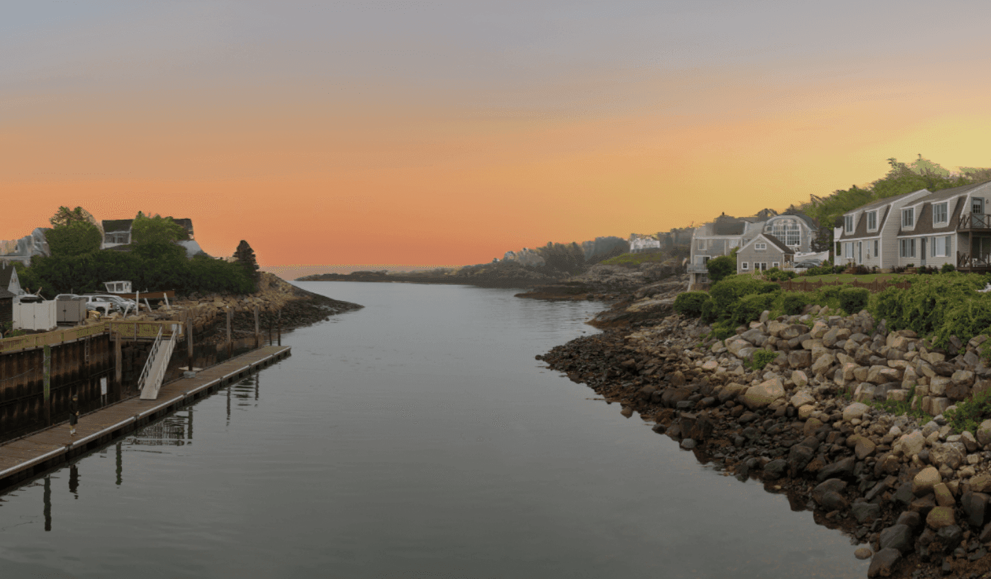 a serene waterfront scene at sunset with houses and docks